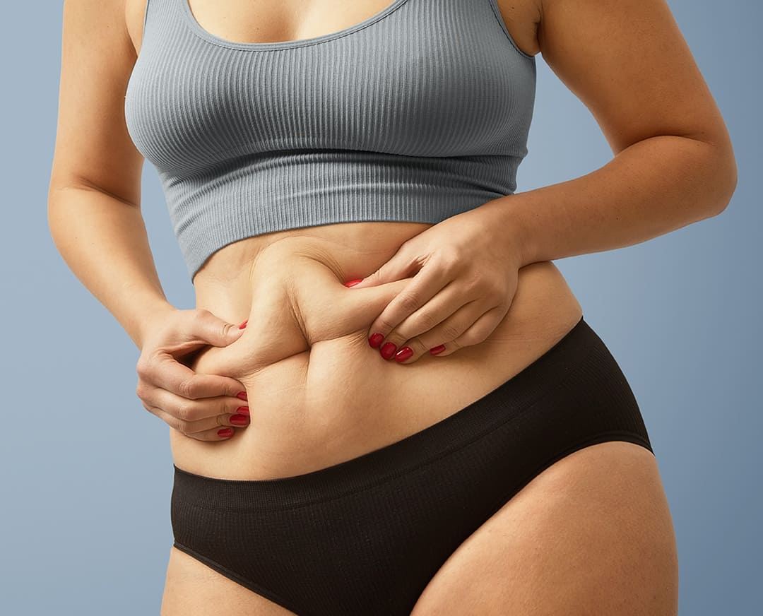 Modelo femenino con un fondo azul representando la reducción de grasa